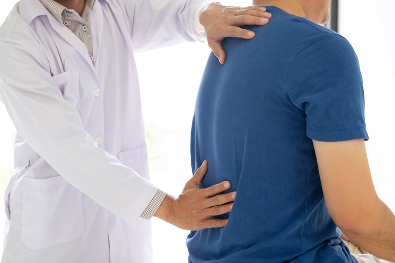 Doctor physiotherapist treating lower back pain patient after while giving exercising treatment on by Ngampol7380, Envato