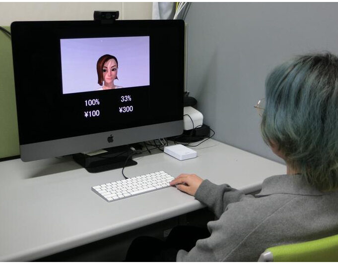 Participants performed a gambling task in the presence of a human observer, choosing between a safe (certain) option and a gamble (probabilistic) option. They were instructed to look at the observer’s face, which was presented either as an avatar or as a real human. Participants were informed that the avatar’s facial expressions and movements mirrored those of the real human observer. The authors found that participants made more gambling choices in the avatar condition than in the human condition. Credit: Toshiko Tanaka (CC-BY 4.0, https://creativecommons.org/licenses/by/4.0/)